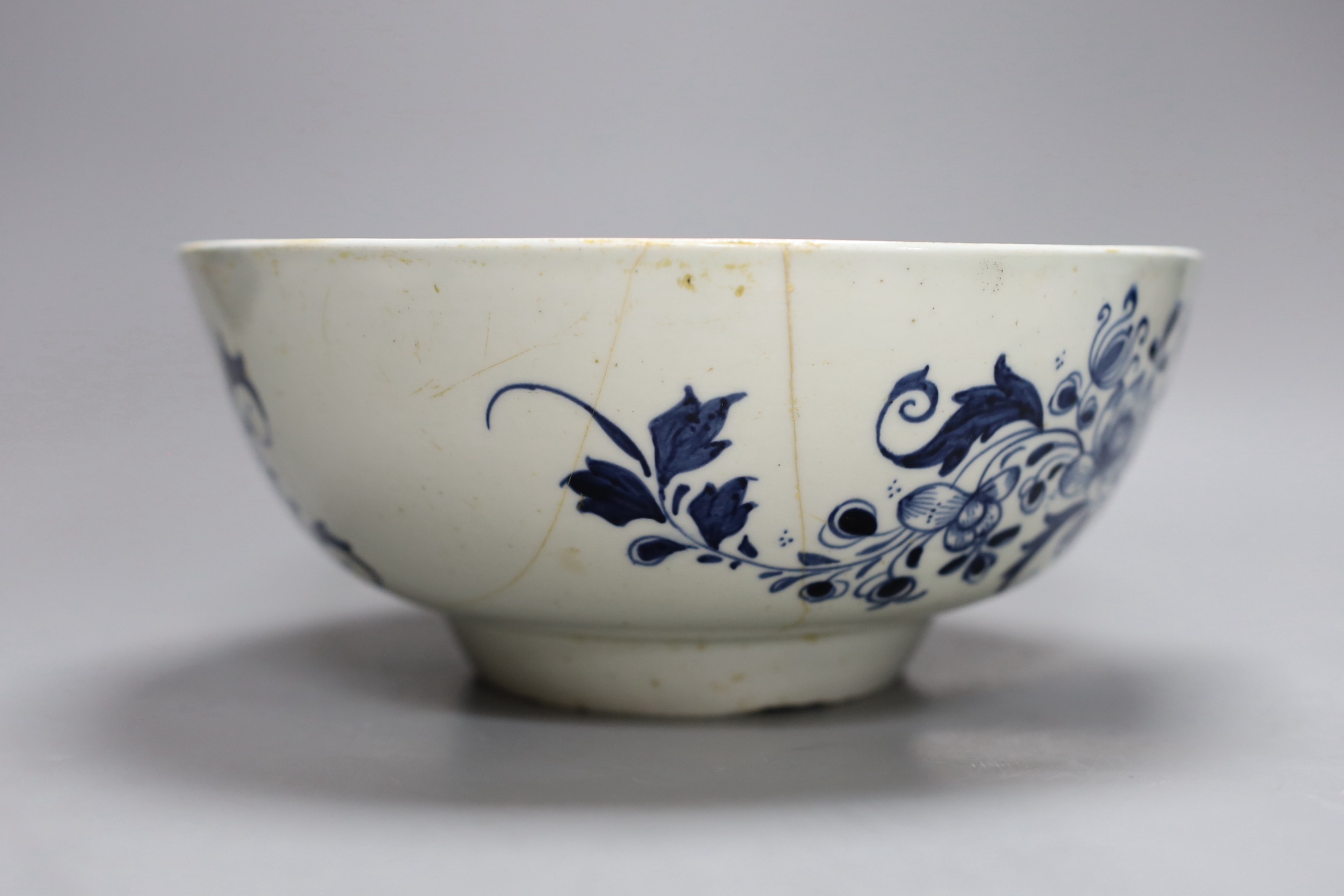 A Liverpool punch bowl, hand painted with flowers and a fence in blue underglaze, 23cm diameter